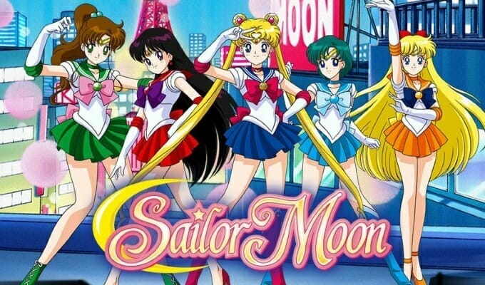 Sailor Moon - the five inner Guardians pose in front of a city.