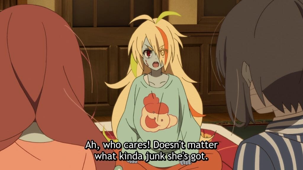 Still from Zombie Land Saga, which sees a blonde zombie woman in a green sweatshirt sayig "Ah, who cares! Doesn't matter what kinda junk she's got."