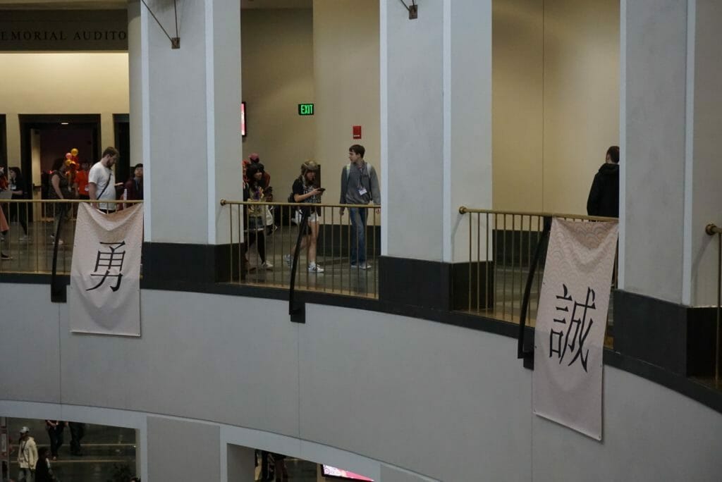 Photo from Anime Boston 2019 that depicts a long-angle shot of a balcony with banners hanging from it.
