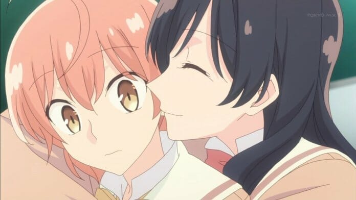 Bloom Into You anime still - a black-haired girl smiles as she wraps her arm around a pink-haired girl.