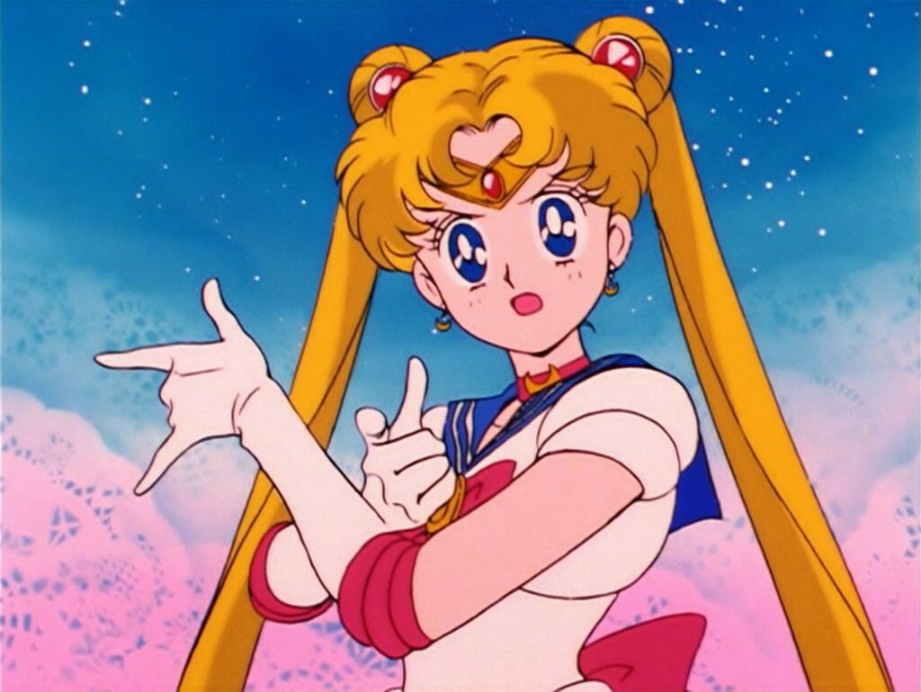 Sailor Moon Anime Still - a blonde girl in a sailor school uniform poses as she faces the camera.