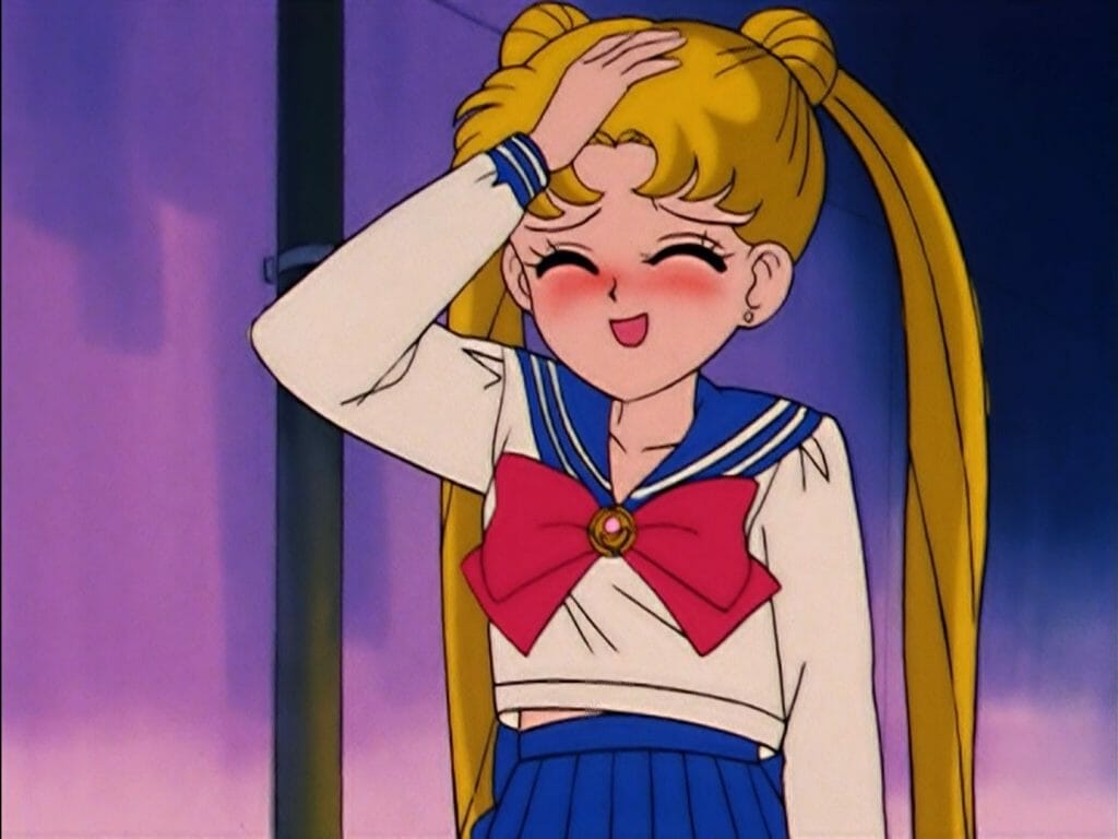 Sailor Moon Anime Still - a blonde girl smiles sheepishly as she holds her hand up to her head.