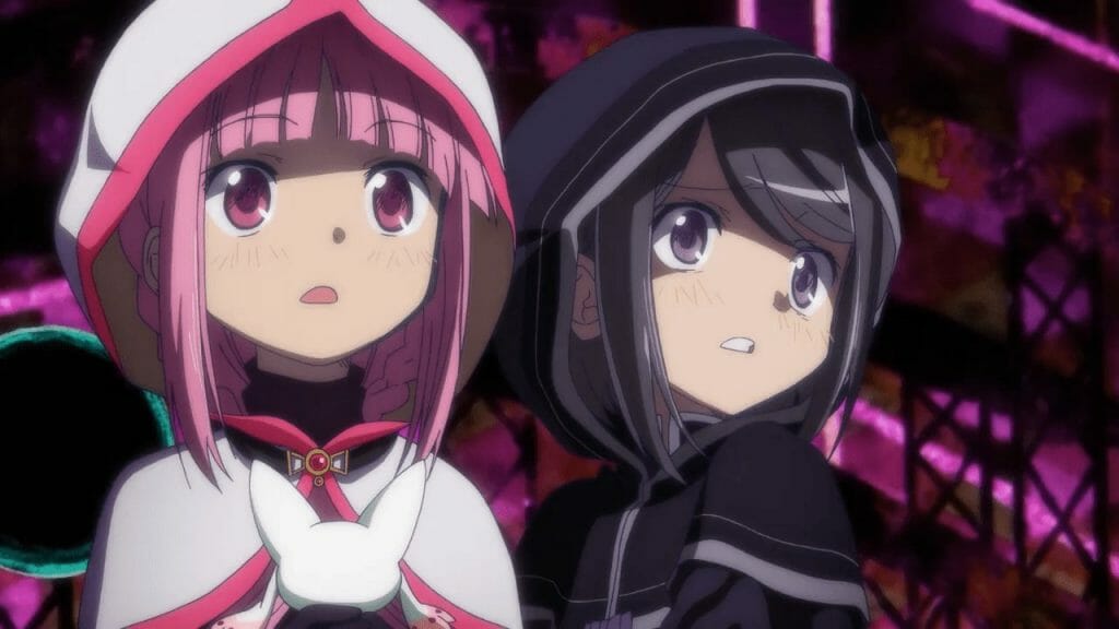 Two girls wearing hoods stare toward an unspecified object offscreen. They're wearing expressions of shock