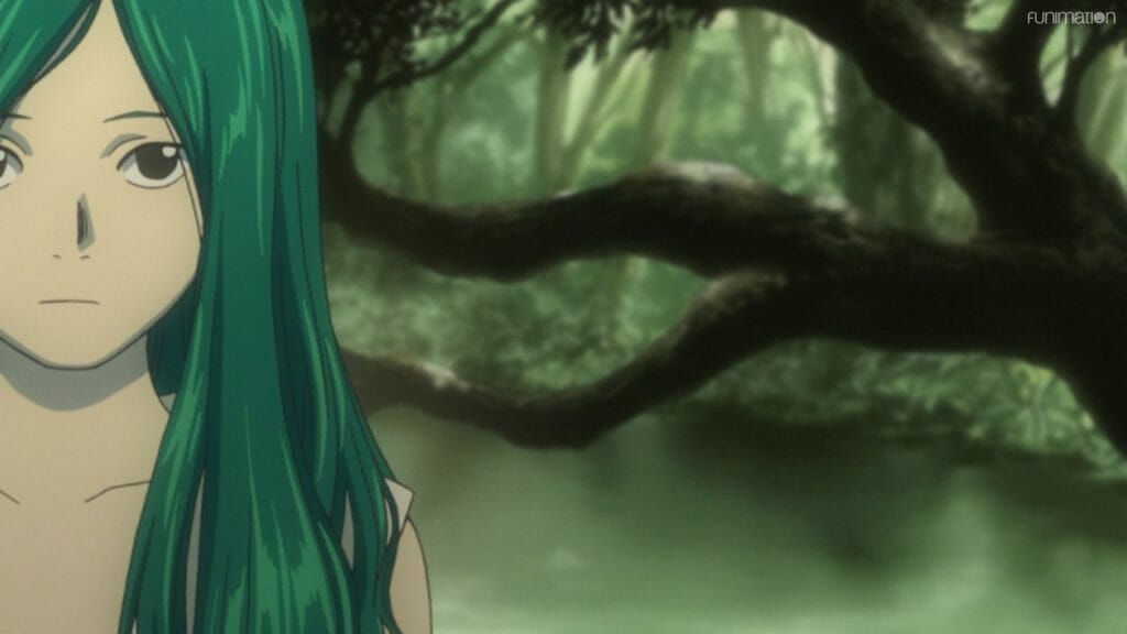 A woman with green hair stands in front of a forest spring.