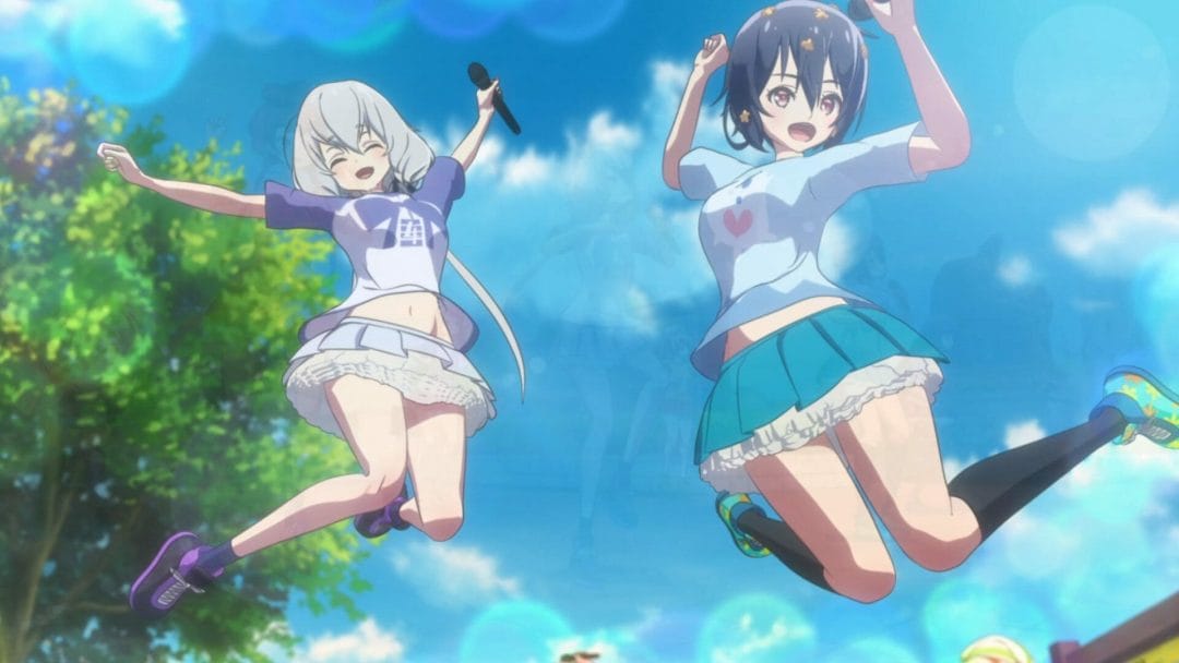 Two women, clad in short skirts and T-shirts jump up in the air. They're both holding microphones.