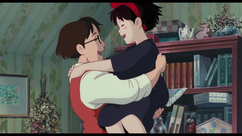 Still from Kiki's Delivery Service, which features Kiki smiling as she hugs her father, Okino.