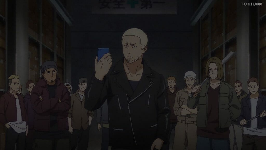 Still from Ikebukuro West Gate Park that depicts a blonde man who stares at a cell phone as he stands in front of a crowd of people.