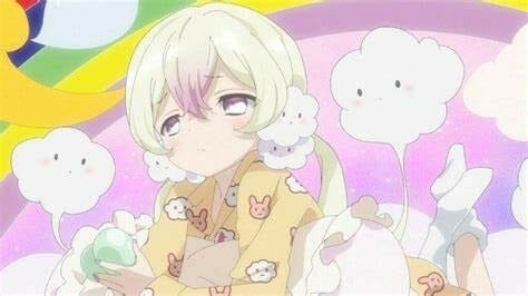 A blonde woman in yellow pajamas gazes sleepily at the camera. She's surrounded by white puffs. 