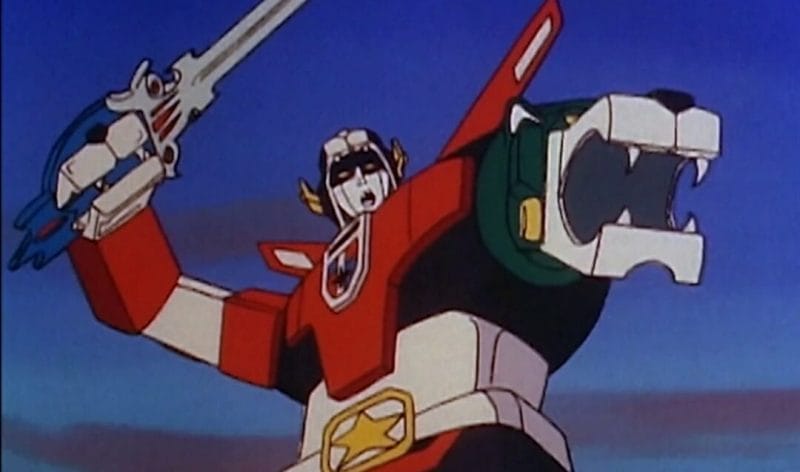 Upper body shot of Voltron: a giant multicolored robot holding a sword.