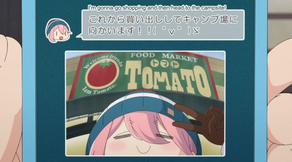 Still from Laid Back Camp, featuring a text message with a photo of Nadeshiko in front of a sign that reads "TOMATO." Text: "I'm gonna go shopping and then head to the campsite!"