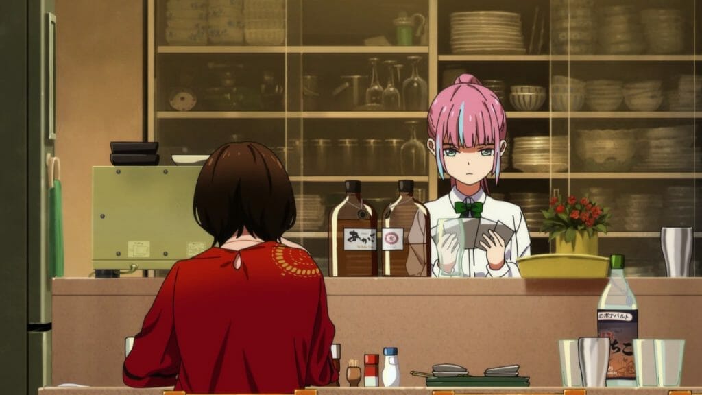 A pink-haired girl looking through photographs while her mother sits idly at a bar