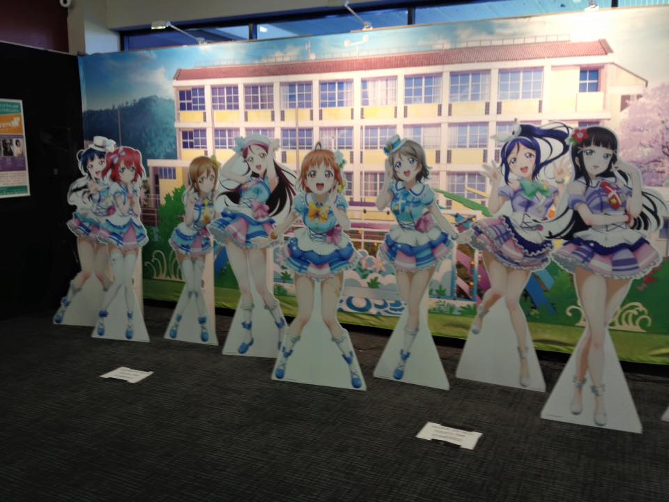 Life-size promotional cut-outs of the Love Live cast on a convention floor