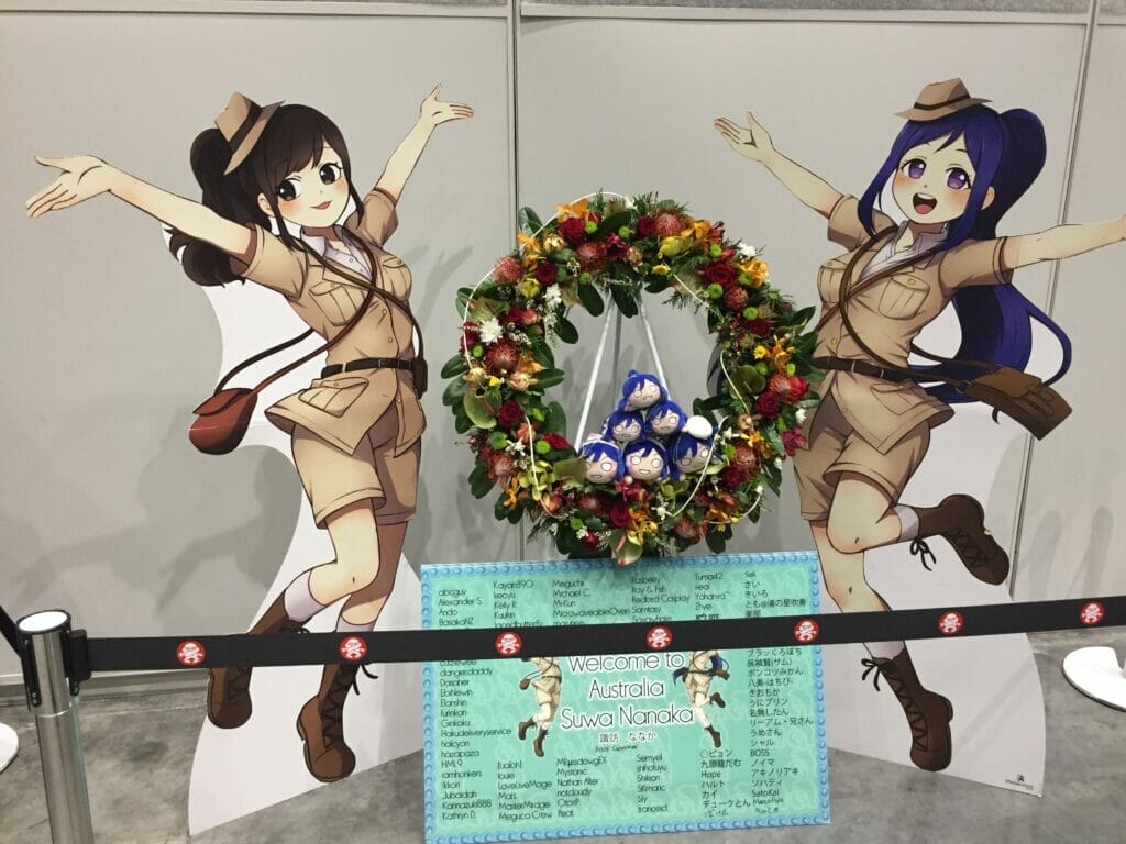 Two promotional cardboard cut-outs of Love Live characters, dressed in khaki explorer gear