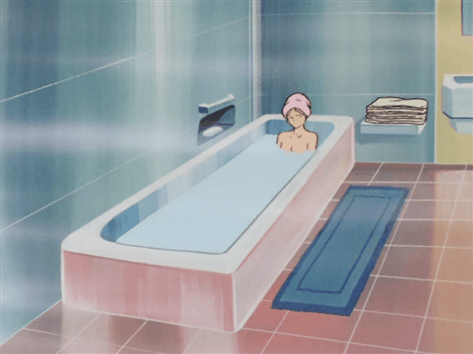 Image of a woman wearing a pink towel on her head as she sits in a bathtub. She is submerged up to her shoulders in the water.