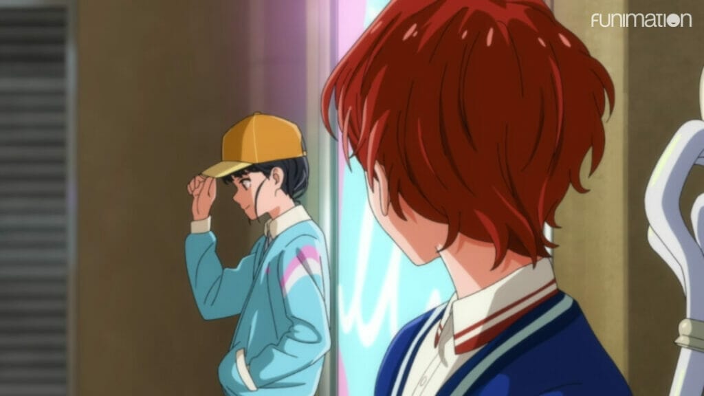 A short-haired girl looking across the frame at a teenaged boy, dressed in the pink, blue and white of the trans pride flag and hiding his long hair under a baseball cap