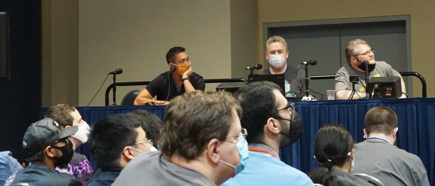 Photo of Justin Sevakis, Mike Toole, and Brady Hartel, seated in front of a crowd at Otakon 2021's Discotek panel.