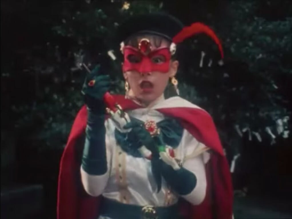 Screenshot from the live-action magical girl show Poitrine, showing a girl in a red mask and cape