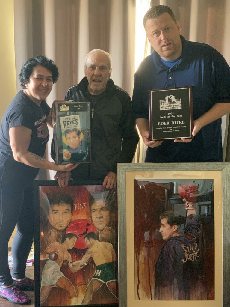 Photograph of Eder Jofre and his family who are holding up various awards.