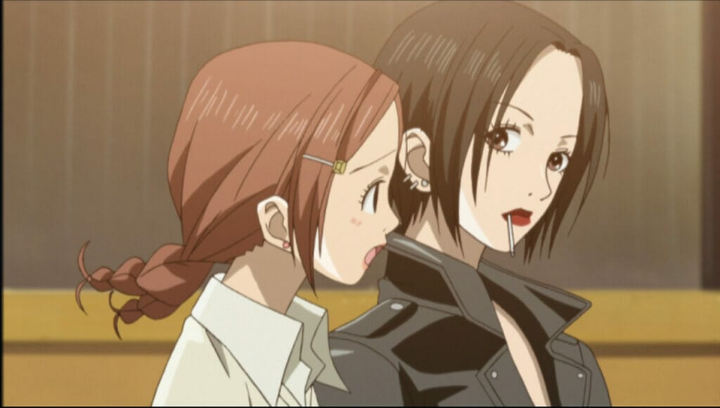 Still from the Nana anime, which depicts a brown-haired woman with a ponytail talking with a dark-haired woman wearing a black leather jacket.