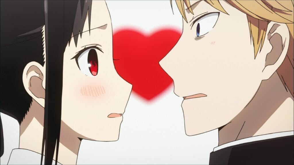 Vẫn từ Kaguya-sama: Love Is War.  Một người phụ nữ tóc nâu và một người đàn ông tóc vàng bối rối nhìn nhau khi một trái tim màu đỏ mờ treo ở hậu cảnh.