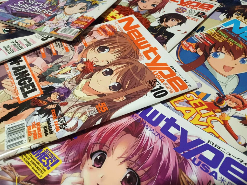 A pile of Newtype USA magazines spread across the frame