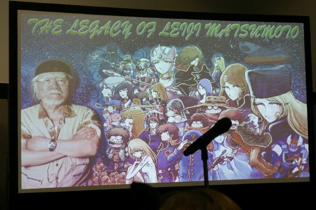 A slide featuring Leiji Matsumoto standing next to a collage of his characters.Text: The Legacy of Leiji Matsumoto
