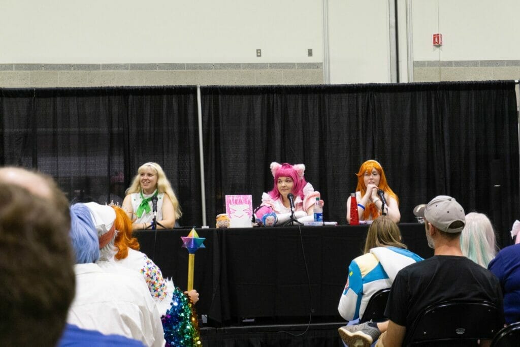 Photo from RI Anime Con that features several cosplayers seated at a panel table.