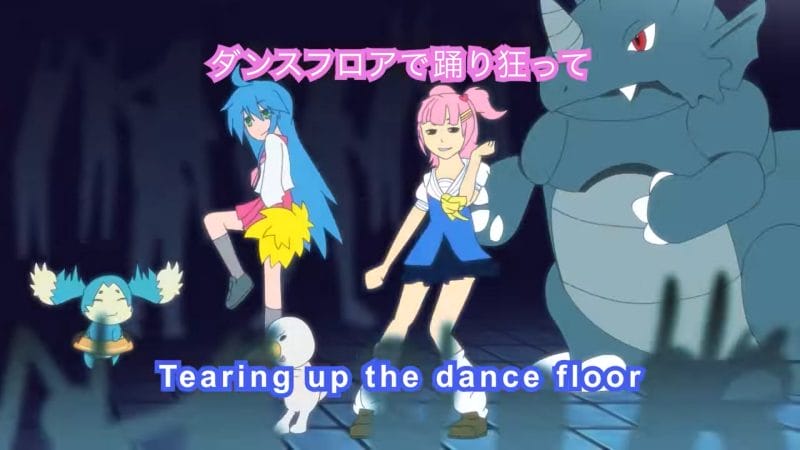 Screenshot from the "She's So Kawaii" music video that features Konoha from Lucky Star doing her dance from the show's intro along with a pink-haired anime-styled girl. Text: "Tearing up the dance floor"