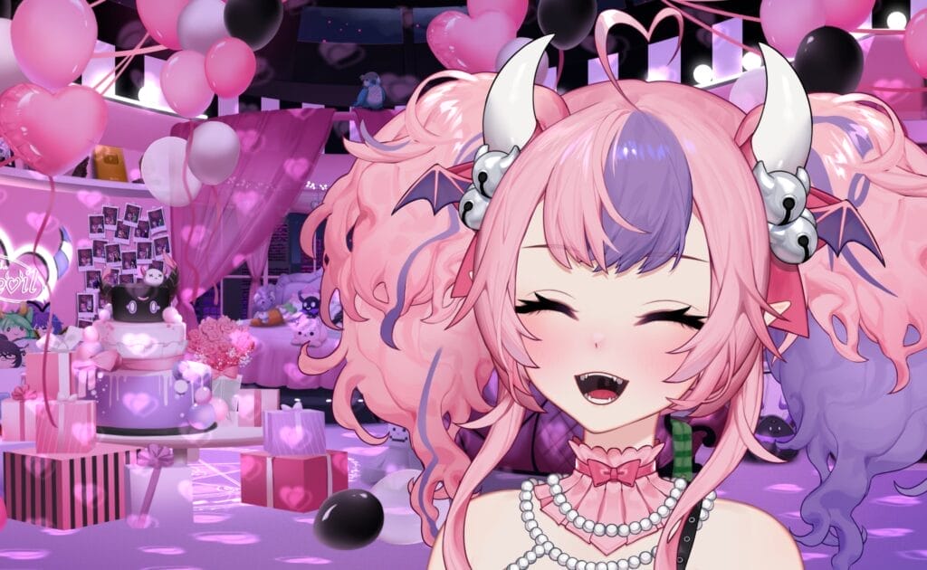 Screenshot of VTuber Ironmouse, a pink-haired demoness with curved white horns. She's smiling as she's surrounded by balloons and gifts.