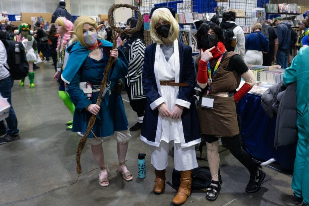 Photo of a group of cosplayers dressed as Marcille, Falin, and Izutsumi from Delicious in Dungeon