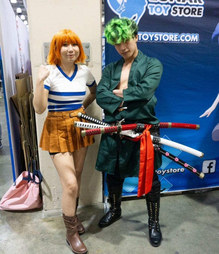 A pair of cosplayers dressed as Nami and Zoro from One Piece