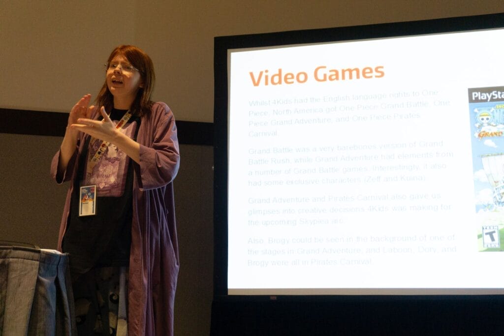 Photo of YouTuber Red Bard stands next to a projection of a washed-out Powerpoint slide that reads "Video Games."
