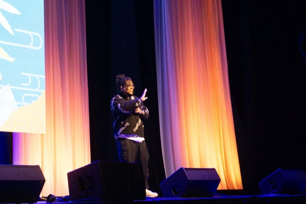Voice actor Zeno Robinson stands onstage at Anime Boston 2024's opening ceremonies