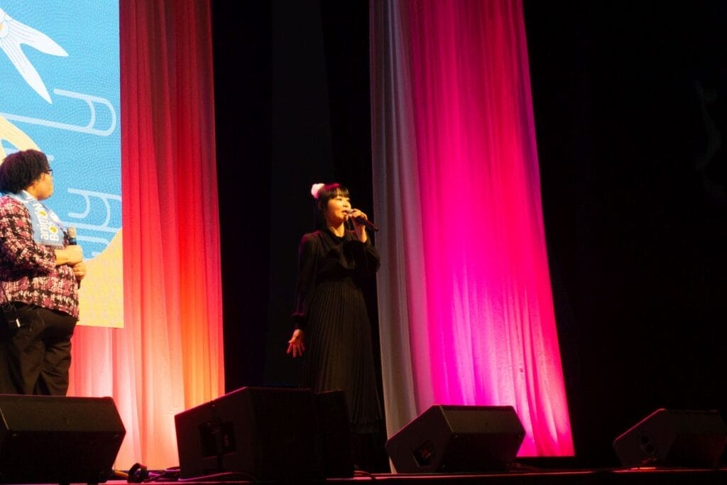 Seiyuu Yukana stands onstage at Anime Boston 2024's opening ceremonies