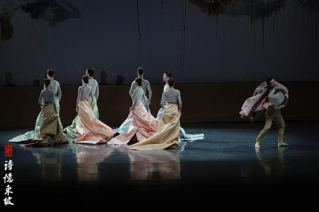Photograph from Dongpo: Life In Poems  that depicts dancers, in colorful skirts, with their backs turned to the audience.