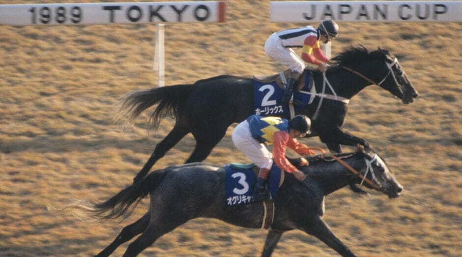 Photo of two race horses running neck-and-neck at the 1989 Tokyo Japan Cup horse race.