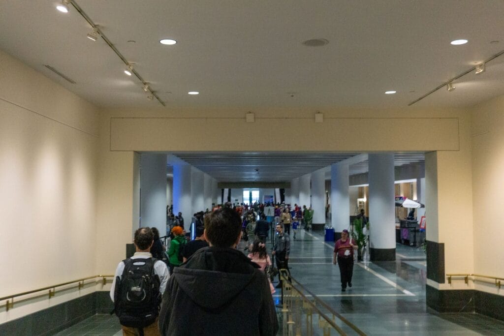 Photograph of people walking through a long hallway into the main lobby of the Hynes Convention Center