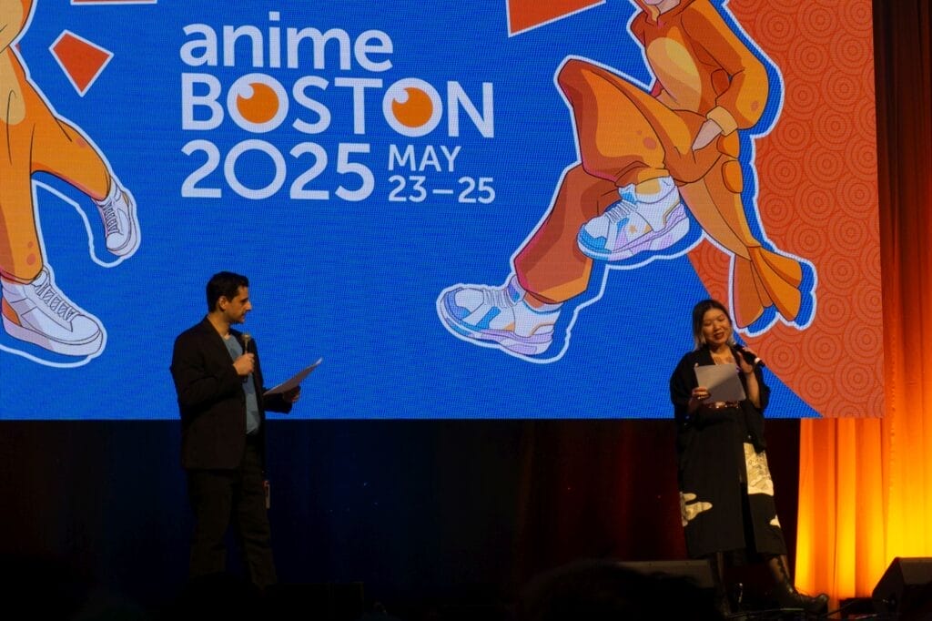 Photograph from Anime Boston 2025's opening ceremonies of convention chairperson Omega Au and vice chair Eric Pescatore