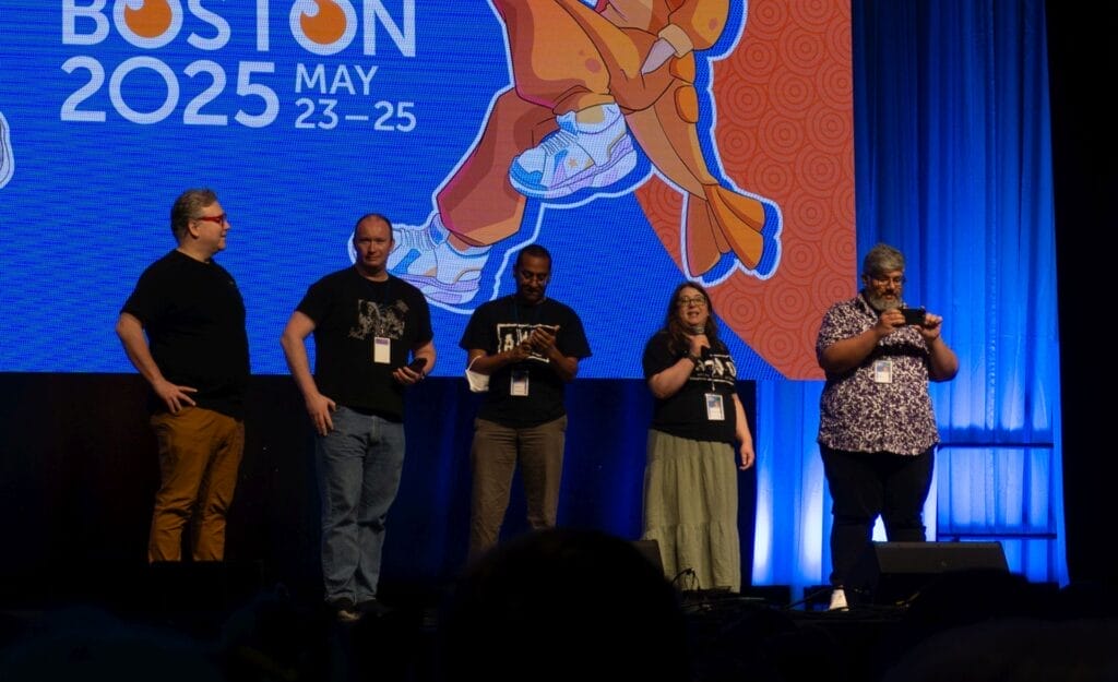 Photograph from Anime Boston 2025's opening ceremonies of Mike Toole, Gerald Rathkolb, Daryl Surat, Clarissa Graffeo, and Jarrett Melendez.